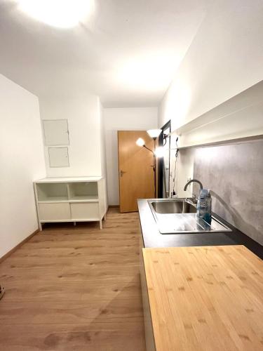 een keuken met een wastafel en een houten vloer bij X-Hain Kiezwohnung in Berlijn