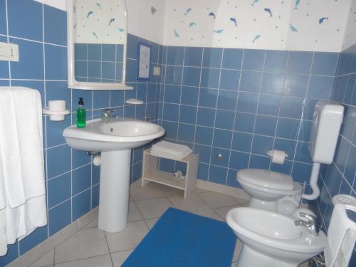 Baño de azulejos azules con aseo y lavamanos en Ca Greta F - Sea View Apartments, en Sal Rei