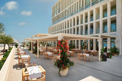 um restaurante com mesas e cadeiras em frente a um edifício em Hotel Ambasador em Split