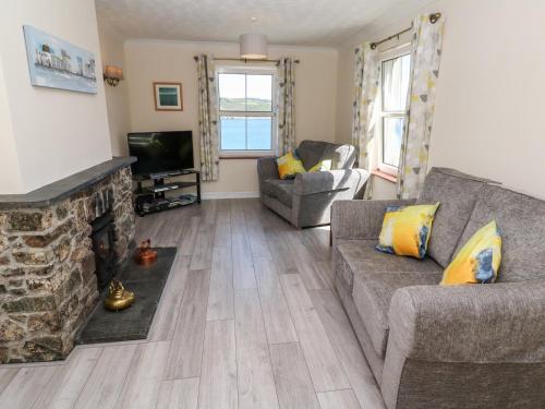 a living room with a couch and a fireplace at The Mariners in Helston