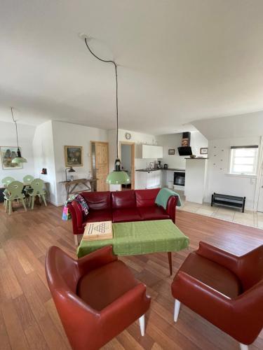 a living room with a red couch and chairs at Ferielejlighed på Elmensbjerg in Asperup