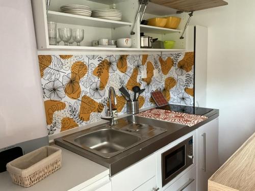 une cuisine avec un évier et un plan de travail dans l'établissement Maison sous les chênes, à Le Gua