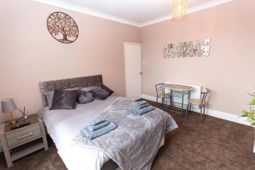 a bedroom with a bed with two blue towels on it at Spalding Town Centre Luxury Private Apartment in Spalding