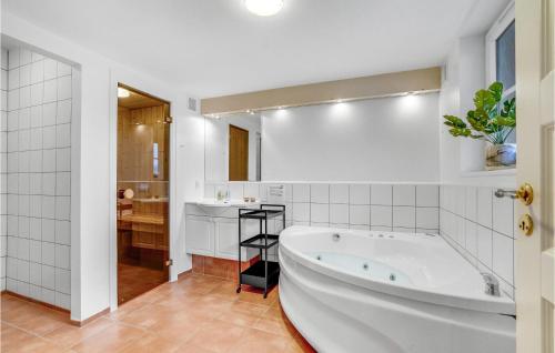 Baño blanco con bañera y lavamanos en Stunning Home In Blvand With 2 Bedrooms, Sauna And Wifi, en Blåvand
