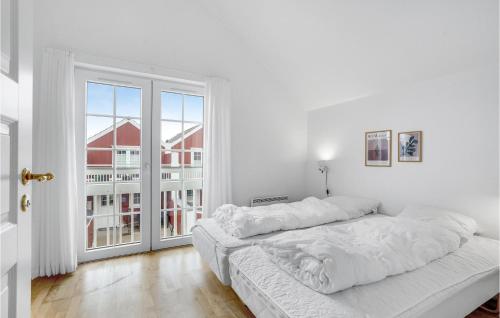 Dormitorio blanco con cama y ventana grande en 2 Bedroom Beautiful Home In Blvand, en Blåvand