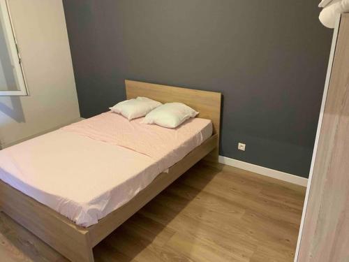 a bedroom with a bed with two pillows on it at Appartement f3 au calme in Florange