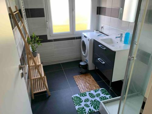 a bathroom with a sink and a washing machine at Appartement f3 au calme in Florange