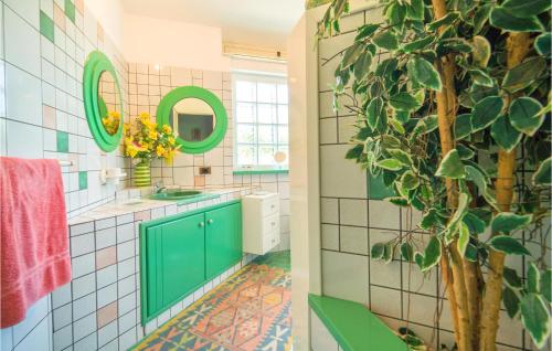 een badkamer met groene kasten en een groene plant bij Beautiful Home In Partinico pa With Outdoor Swimming Pool in Balestrate
