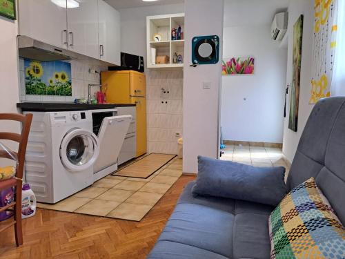 a living room with a washing machine and a couch at Apartments Jessica in Krk