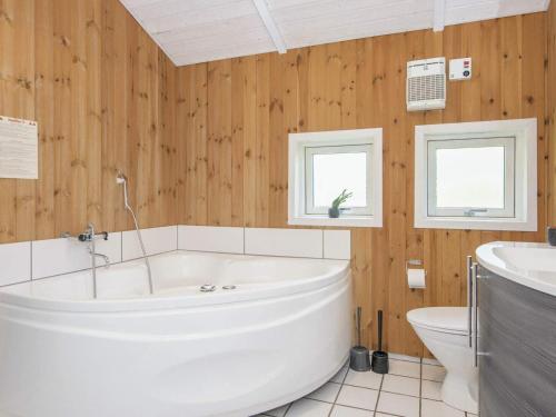 Fjellerupにある8 person holiday home in Glesborgの木製の壁のバスルーム(白いバスタブ付)
