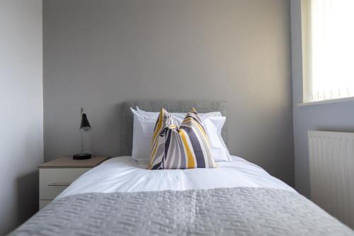 a white bed with two pillows on top of it at Workers & Visitors- Gainford 4Bedrooms in Walsgrave on Sowe