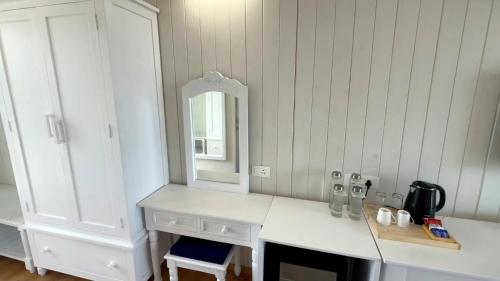 a white kitchen with a counter and a mirror at Praveg Beach Resort Diu, Chakratirth Beach in Diu