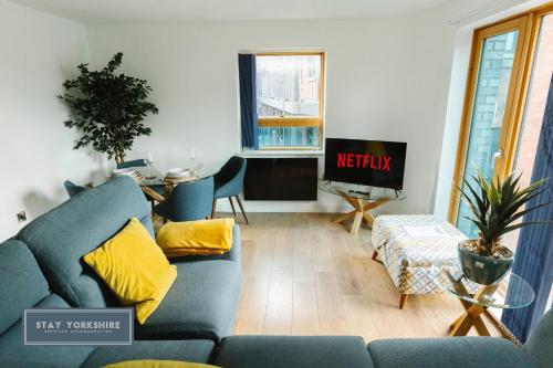 a living room with a blue couch and a tv at Stay Yorkshire IQ 4 Blonk Street in Sheffield
