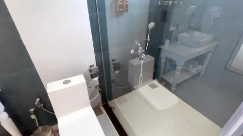 a small bathroom with a toilet and a sink at Praveg Beach Resort Diu, Chakratirth Beach in Diu