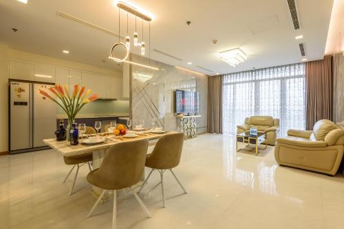 Landmark Vinhomes Christine Apartment في مدينة هوشي منه: مطبخ وغرفة معيشة مع طاولة وكراسي