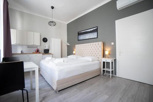 1 dormitorio con 1 cama blanca grande y cocina en Bright ,cozy , central and cute studio in Vienna, en Viena