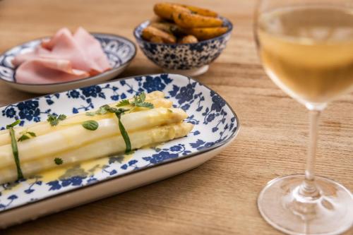 a plate of food and a glass of wine on a table at Small Luxury Hotel Goldgasse in Salzburg