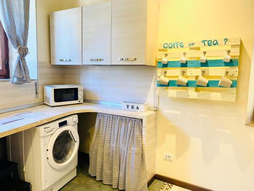 a kitchen with a washing machine and a microwave at Il Gatto Nero in Coreglia Antelminelli