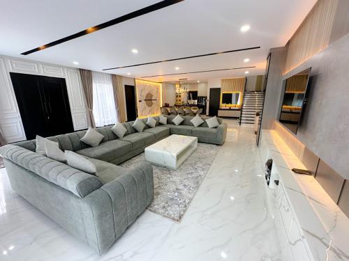 a large living room with a couch and a table at Villa London Puncak in Sampal 2