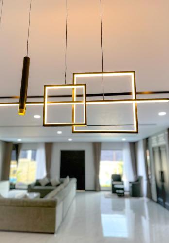 a living room with a couch and a chandelier at Villa London Puncak in Sampal 2