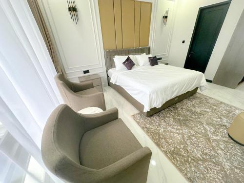 a bedroom with a bed and a couch and a chair at Villa London Puncak in Sampal 2