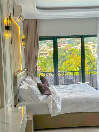 a bedroom with a bed with a large window at Villa London Puncak in Sampal 2