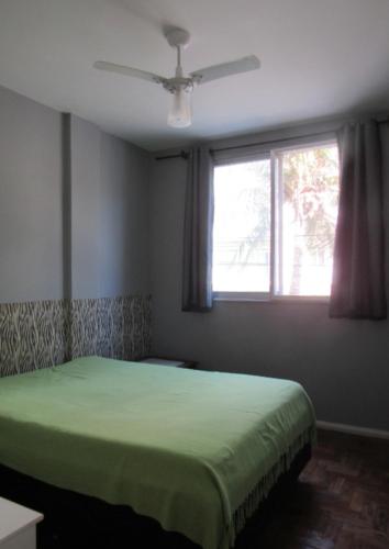 - une chambre avec un lit vert et une fenêtre dans l'établissement Apto acochegante em Cabo frio e a um minuto da areia. Vai a pé a praia do forte., à Cabo Frio