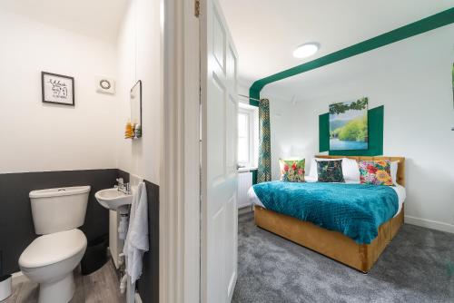 een slaapkamer met een bed, een toilet en een wastafel bij Aseda 4 BedRoom Private Parking, Game Zone -Pool table, Garden Home in Hull