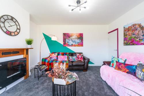 a living room with a couch and a fireplace at Aseda 4 BedRoom Private Parking, Game Zone -Pool table, Garden Home in Hull