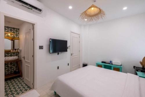 a bedroom with a bed and a flat screen tv at Pisces Hotel Hue in Hue