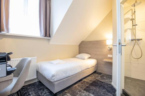 - une petite chambre avec un lit et une douche dans l'établissement Fletcher Hotel Landgoed Huis te Eerbeek, à Eerbeek