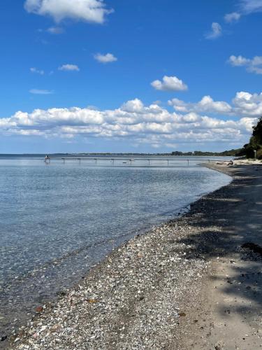 a beach with a bridge in the water at Ferielejlighed på Elmensbjerg in Asperup