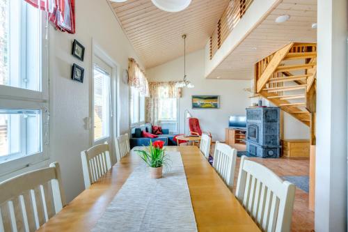 a living room with a table and chairs and a staircase at Lomahuoneisto Kalajoen Hiekat C 6 in Kalajoki