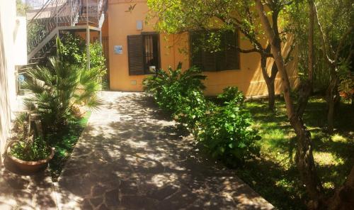 a garden with plants and a building and a sidewalk at B&B Villa Giglio in Catanzaro
