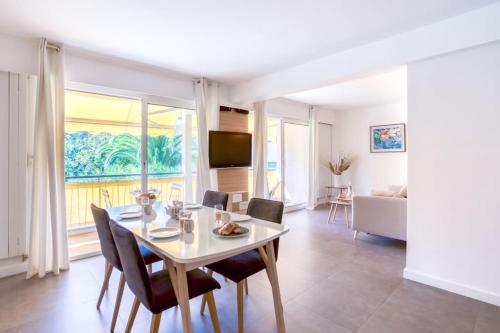 un salon avec une table, des chaises et un canapé dans l'établissement C9 - 2 BDR 10 min Palais Festivals & Sea - AC, Parking & Balcony, à Cannes