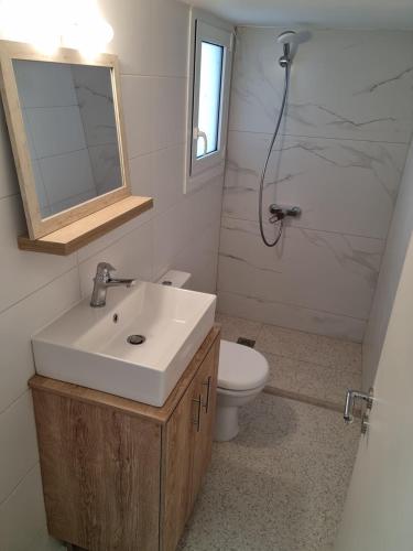 a bathroom with a sink and a toilet and a mirror at New house in Pireas port in Piraeus