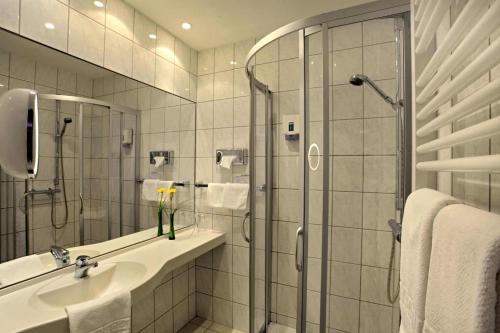 W łazience znajduje się prysznic i umywalka. w obiekcie Lampes Posthotel w mieście Grünenplan