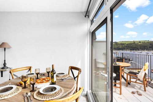 a dining table with a view of a balcony at Harbourside 3 - Luxury Riverside Apartment in Dartmouth