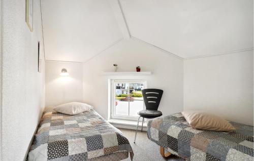 een slaapkamer met 2 bedden en een stoel bij 3 Bedroom Awesome Apartment In Bogense in Bogense