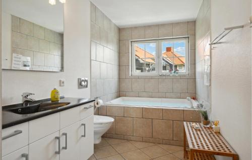 e bagno con vasca, servizi igienici e lavandino. di 3 Bedroom Awesome Apartment In Bogense a Bogense