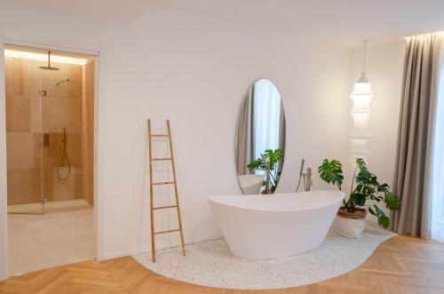bagno con vasca bianca e scala. di Neró Rooms a Taormina