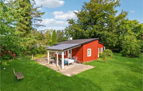 a red shed with a porch in a yard at 3 Bedroom Nice Home In Gilleleje in Gilleleje