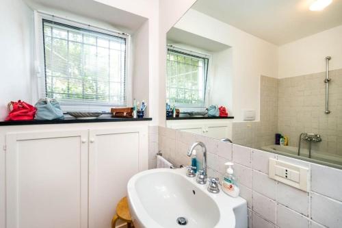 ein weißes Badezimmer mit einem Waschbecken und einem Spiegel in der Unterkunft CHARMING APARTMENT VILLA WITH POOL 010-46-cav-0009 in Rapallo