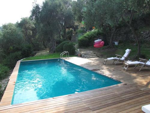 einen Pool auf einer Holzterrasse mit Stühlen und einer Rutsche in der Unterkunft CHARMING APARTMENT VILLA WITH POOL 010-46-cav-0009 in Rapallo