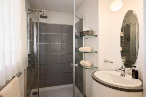 a bathroom with a sink and a shower at Dolomit Boutique Hotel in La Villa