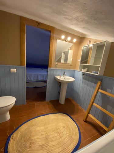 a bathroom with a sink and a toilet and a mirror at Casa Rural Los Almendros in Málaga