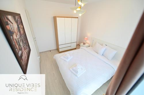 a small bedroom with a white bed and a mirror at FLH - Unique Vibes Residence Magnolia Sibiu in Sibiu