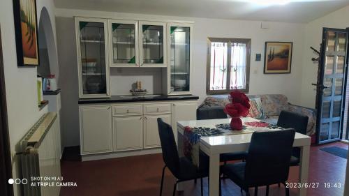 Il comprend un salon avec une table et des chaises ainsi qu'une cuisine. dans l'établissement Case vacanze Corrado 2, à La Capriola