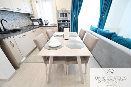 a small kitchen with a white table and chairs at FLH - Unique Vibes Residence Magnolia Sibiu in Sibiu