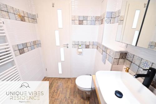 a bathroom with a toilet and a sink at FLH - Unique Vibes Residence Magnolia Sibiu in Sibiu